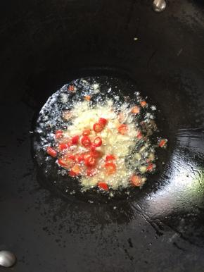 锅烧热倒入适量的油，放入蒜瓣，生姜，花椒，干辣椒和红尖椒爆香。