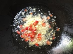 锅烧热倒入适量的油，放入蒜瓣，生姜，花椒，干辣椒和红尖椒爆香。