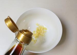 碗中放入蒜泥，少许糖，一勺生抽