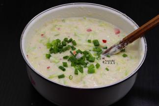 把面粉倒入，加入适量的清水，然后把切的红辣椒、香葱分别加入拌均成面糊，喜欢吃软的煎饼，多加点水，喜欢吃脆香的可以少加点水。