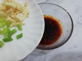 再把切碎的蒜和葱放入碗中