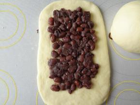 放上蜜豆用手轻轻的压实然后自上而下的卷起来