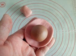 取粉色面团30克的两份，揉几下，包入步骤7的可可面团，剩下的粉色面团放冰箱备用。(蓝色面团，紫色面团，黄色面团也是如此)