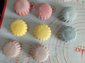 包好的面团揉圆，裹一点点干粉，用月饼模具压一下，再用刮板把周围的压痕加深一下，盖保鲜膜放冰箱备用