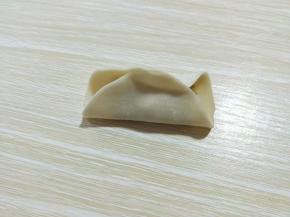先对折，捏紧，如图。