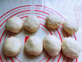 发酵好的面团从面包机取出，盖上保鲜膜排气10分钟，再分割成小面团，揉圆。盖上湿布醒10分钟。