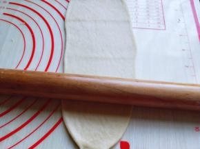 取一小块面团用擀面杖擀长舌状。