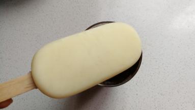 再把冻好的雪糕脱模取出来，放入融化的巧克中沾满巧克力。
