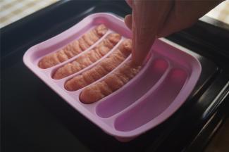 慢慢挤到火腿肠硅胶模具中，往上突出一点点也无所谓。