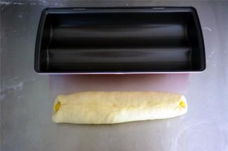 白色面团紧紧包裹住黄色面团，收口捏紧，轻轻混动搓平。