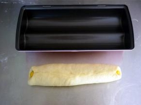 白色面团紧紧包裹住黄色面团，收口捏紧，轻轻混动搓平。