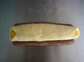 将粗细两条可可面团分别放在白色面团两旁，如图。