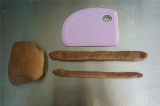 可可面团中，称量50克，20克两个面团，分别揉成21厘米的长棒状。