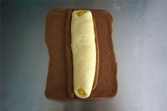 剩余的可可面团，擀成21*18厘米的面片，将步骤14包裹住。