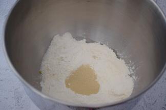 把材料都放入和面桶，顺序为纯牛奶、鸡蛋液、玉米油，糖和盐对角放，然后放奶粉和面粉，酵母放最上面