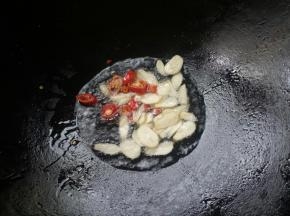 锅烧热下油，放入蒜瓣和辣椒爆香。