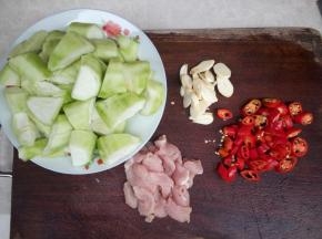 丝瓜切滚刀块，蒜切片，红椒切小段，肉切片，肉用料酒、生抽和淀粉腌制10分钟。
