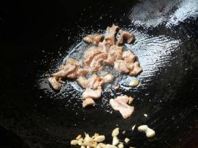 锅烧热下油，蒜爆香。放入腌制好的肉片，炒至肉片变色盛出。