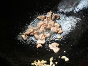 锅烧热下油，蒜爆香。放入腌制好的肉片，炒至肉片变色盛出。