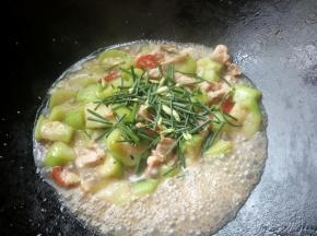 放入韭菜花和适量盐翻炒。