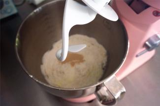 将主食材中除黄油外的食材投入厨师机，先低速后高速揉面。