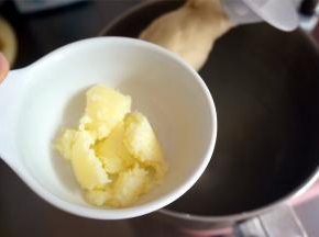 揉至面团光滑出现筋性后加入软化的黄油，先低速后高速继续揉面。