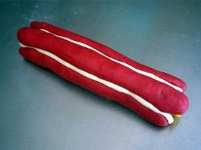 用红色的棒状面团围住黄色的花心面团，放的时候注意大小相隔，其中两个红色花瓣之间放入一条白色棒状面团，并用刮板稍微按压一下，这样更能突出花瓣的形状。