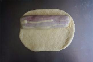 最后，将剩下的白色面团擀成21*8厘米的面片，包裹在最外面，捏紧开口。