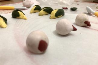 白与红色面团搓揉成圆，捏出桃尖。