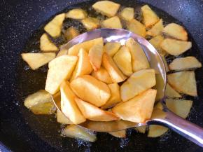 锅中放油烧热土豆块放进去油炸至微黄控油捞出
