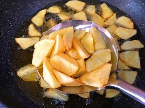 锅中放油烧热土豆块放进去油炸至微黄控油捞出
