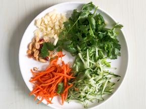 胡萝卜和黄瓜刨丝，蒜瓣和香菜切碎，熟的花生一汤匙拍碎