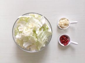 半边包菜用淡盐水浸泡洗净，手撕小块，蒜瓣切碎、辣椒切段