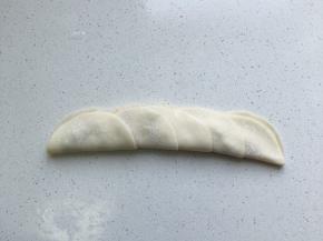 放少量肉馅在饺子中间，再将饺子皮翻过去覆盖住肉馅