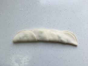 放少量肉馅在饺子中间，再将饺子皮翻过去覆盖住肉馅