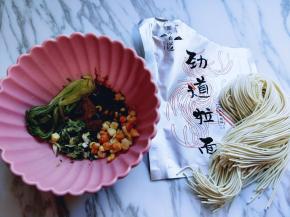 将配菜及牛肉放入大口器具中。拉面从包装里取出。