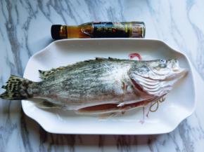 将洗干净的桂鱼放入鱼盘中。