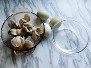 泡好的蛤蜊需要焯水，锅中加入清水，加入料酒，生姜烧开，加入蛤蜊，煮开口即可关火，捞出纯净水冲洗干净。