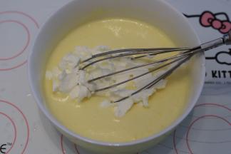 分三次将蛋黄液加入淡奶油内，轻轻搅拌均匀