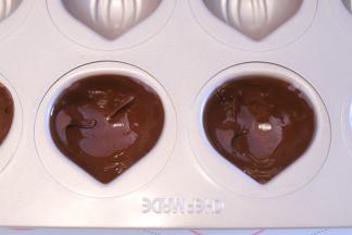 分别倒少许巧克力液到学厨的板栗12连模内，轻晃至巧克力液粘满模具