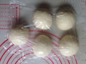 发酵好的面团取出，轻压排气，分成5等份，滚圆并盖上保鲜膜，静置15分钟，静置过的面团再擀开不易回缩