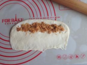 面团擀成椭圆形，翻面，光滑面朝下，下面那条长边擀薄一些，在顶端挤上沙拉酱，放上肉松，也可以换成其他果酱之类，不加也很好吃哒