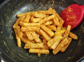 下炸好的南瓜条，晃动锅子，让它裹匀即可。