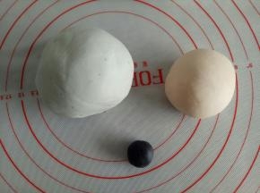 取3克面团揉入竹炭粉，取大概110左右面团揉一点点红曲粉，成粉色面团，剩下的面团分出3克来揉入蝶豆花粉做成淡蓝色面团