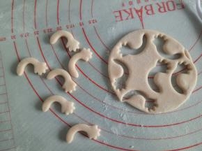 剩余淡粉色的面团揉一下，擀厚一点，大概2mm厚，用模具压出猪猪的胳膊来(没有模具可以先取2克面团揉成长条，稍微压扁，一头用刮板整成手掌状)