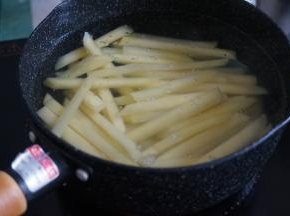 锅里的水烧开后，放入盐，再倒入土豆条，煮2分钟左右，不用把土豆煮软，煮到土豆条还是比较硬的状态