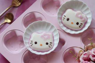 巧克力隔水融化，放入裱花袋，胡萝卜切成小薄圆片，牙签沾火龙果液涂抹蝴蝶结，来装饰奶冻。