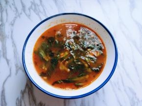 将泡开的青菜，牛肉料理包，豚骨番茄汤底倒入大碗中。