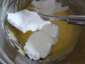 将打发好的蛋白分三次加入蛋黄糊中，第一次加入到蛋黄糊后用手动打蛋器同样的手法混合均匀