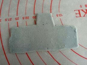 剩余蓝色面团再揉入一点蝶豆花粉做深蓝色面团，擀薄用刮板切出如图猪猪的衣服来